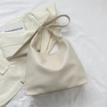Minimalistische beige Hobo-Tasche aus Leder mit Narbenstruktur und Schultergurt - Gebrochenes Weiß