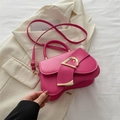 Sacoche en cuir magenta avec boucle dorée en D sur fond de blazer beige élégant - rose vif