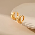 Elegant gold croissant-style ribbed hoop earrings on a minimalist white ceramic display - Gold Croissant Earrings