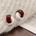 Dettaglio macro di orecchini vintage a forma di C con smalto bordeaux e bianco lucido - Bianco e Rosso Ankara