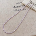 Pink pearl necklace featuring a silver heart-shaped clasp on a rustic beige linen fabric - Taro Purple Pearl (4mm)