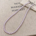 Elegant lavender pearl necklace with silver metal clasp on a rustic beige linen background - Taro Purple Pearl (6mm)