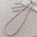 Elegant lavender pearl necklace with a silver heart clasp on beige linen fabric - Taro Purple Pearl (8mm)