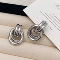 Detail von silbernen mehrlagigen Creolen mit glänzendem poliertem Metallfinish - Silber