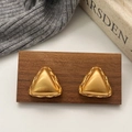 Orecchini a triangolo in oro spazzolato con trama intrecciata su sfondo legno vintage - Orecchini a lobo a triangolo in oro spazzolato