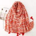 Sciarpa etnica con stampa paisley rossa e nappe accanto a una rivista moda - Taglia unica / Paisley Rosso e Grigio (SL2306-031)