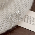 Detail of silver bow earrings resting on white knit fabric with an aesthetic card - Silver (A-1213)