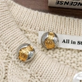 Detalle macro de pendientes esféricos bicolor oro y plata con ranuras de ondas finas - Bicolor Oro y Plata