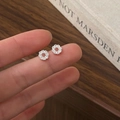 Close-up of minimalist silver wreath earrings with sparkling zircon stones held by fingers - Silver