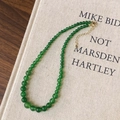 Dettaglio della collana di calcedonio verde con chiusura dorata su libro antico - Calcedonio Verde (B-531-Calcedonio Verde)