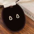 Detailed view of gold Wu Lou stud earrings with pavé zircons in a velvet jewelry box - Gold