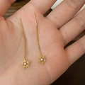 Detail der goldenen Schneeflocken-Ohrhänger mit langer Kette und funkelndem Zirkonia - Goldener langer Ohrfaden / Gold