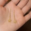 Detailansicht der goldenen Schneeflocken-Ohrhänger mit Zirkonia auf einer Hand - Goldene Kurze Ohrenfäden / Gold