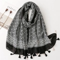 Dettaglio della sciarpa con motivo geometrico bianco e nero, frange e tocco di cotone - Nero