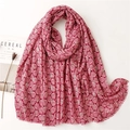 Detailed macro view of rose red linen scarf with white feather patterns and fringe edge - Red