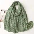 Détail d'une écharpe verte avec motifs d'arbres blancs et fines bordures à franges à plat - Vert