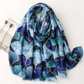 Blue ginkgo leaf print scarf with gold trim shown from a 45-degree angle - Blue