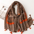 Detalle de bufanda gruesa de invierno con patrón de espiga marrón y borlas de color naranja - Estilo de Borde Naranja