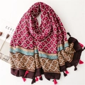 Detail of ethnic geometric patterns and red fringe tassels on a cotton linen scarf - Red