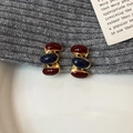 Dettaglio di orecchini vintage a perno con resina rossa e blu e base in metallo dorato - Tonalità Rosso Angola