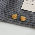Orecchini a lobo a cuore dorati con trama a rete su sfondo minimalista in maglia grigia - Orecchini a Lobo a Cuore in Maglia Cava Dorato (A-616)