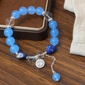 Bracciale di perline blu cielo con pietre acquamarina e ciondoli su base in legno - Blu