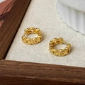 Dettaglio ravvicinato di orecchini a cerchio dorati con design a catena vuota - Oro