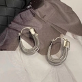 Detalle de elegantes pendientes plateados en forma de U con capas de cuentas sobre fondo moda - Plateado