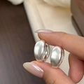 Primer plano de pendientes plateados con elegante acabado mate y textura cepillada - Plateado
