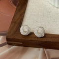 Dettaglio orecchini a nodo d'argento intrecciato con texture metallica sofisticata - Stile Anello a Spirale Annodato (A-1312)