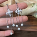 Detalle de pendientes de flores de cuatro pétalos con perlas y borlas largas - Plateado
