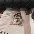 Detail of silver irregular lava fluid ear cuff resting on a stylish magazine surface - Silver