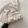 Crème geplooide shopper met leren strik en sternieten in een minimalistische setting - Wit