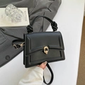 Elegante zwarte leren handtas met geknoopte handgreep en gouden draaisluiting - Zwart