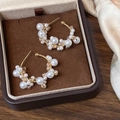 Detalle de pendientes de aro dorados con perlas y cristales de champán en caja - Champán (Pendientes de cristal naranja)