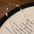 Close-up of delicate gold-plated pearl necklace on vintage literary background cloth - Shell Pearl (B-559)