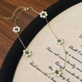 Collana a fiori placcata oro con perle bianche e accenti verdi su base di legno scuro - Verde