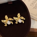 Detailed macro view of gold-plated orchid earrings with pear-cut zircon in velvet box - Gold