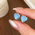 Light blue heart enamel hoop earrings with silver bow design on a wood background - Silver Blue Heart (Bow)