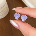 Detail of silver heart earrings with purple enamel and a tiny bow worn on hand - Silver Purple Heart (Bow)
