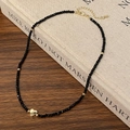 Detail einer Perlenkette mit goldenem Herzanhänger auf antikem Buch und Holztisch - Gold Herz Stil
