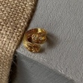 Detailweergave van een luxe gouden gelaagde golfring op steen en linnen textuur - Goud