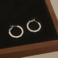 Close-up of small silver textured hoop earrings with a metallic woven pattern finish - Rhombus Texture Style (A-1305)