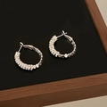 Detailed view of silver hoop earrings with white zircon pavé on a dark display stand - Pavé Rhinestone Metal Dot Splice Style / Silver