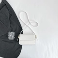 Vue de dessus d'un sac carré blanc minimaliste avec détails dorés et cuir synthétique lisse - Blanc
