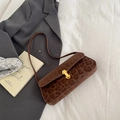 Braune Baguette-Tasche mit Leopardenmuster und Goldschließe auf grauem Blazer - Braun