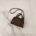 Bolso bandolera vintage de ante y cuero marrón con asas sobre fondo blanco suave - Café sin Colgante