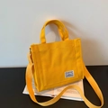 Minimalist bright yellow canvas tote bag with adjustable shoulder strap and hand straps - Yellow