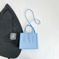 Sky blue square handbag with dual handles and long shoulder strap on white background - Blue