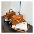 Close-up of orange grained leather mini bag with gold hardware and top handle detail - Brown